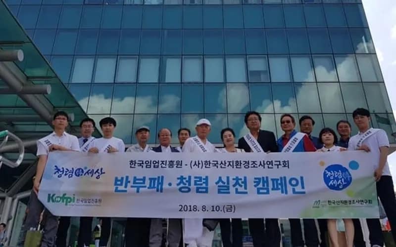 한국임업진흥원과 함께 '반부패·청렴 실천 캠페인' 현수막을 펼쳐 든 연구회 임직원들이 역사 앞에 줄지어 서 있는 모습