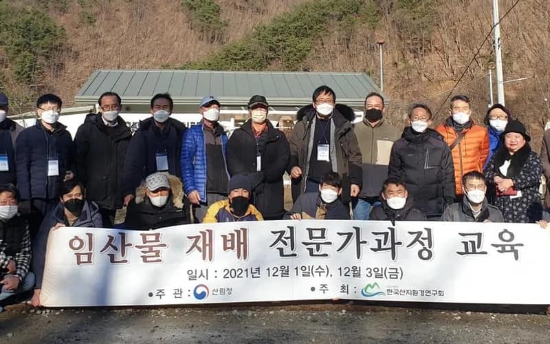 '임산물 재배 전문가과정 교육' 현수막을 앞에 두고 산자락 교육장에 모여 선 수강생과 강사진