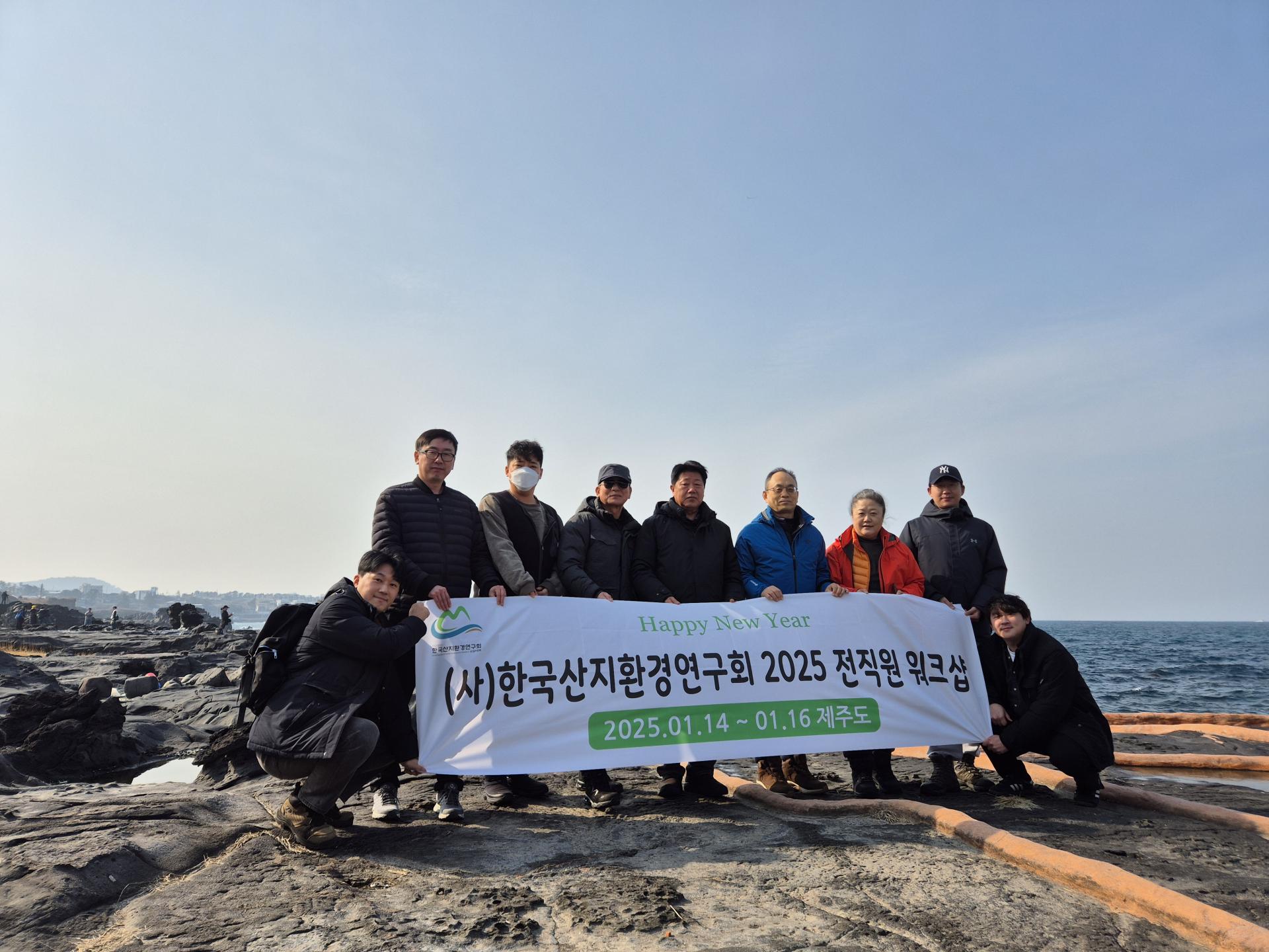 제주 해안 바위에서 '2025 전직원 워크샵' 현수막을 들고 단체로 기념하는 직원들 (2025년 1월 14~16일)