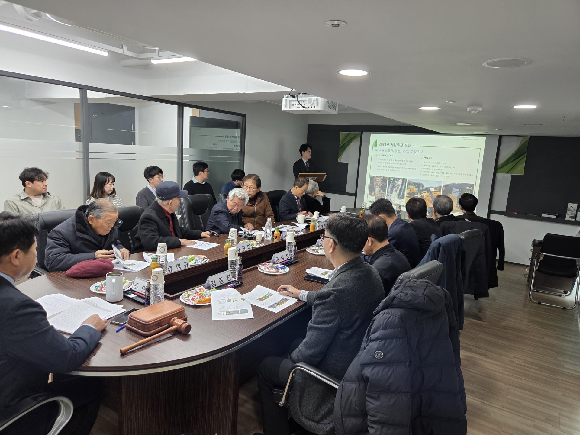 제30차 정기총회: 발표 화면 앞에서 안건 보고가 진행되는 모습