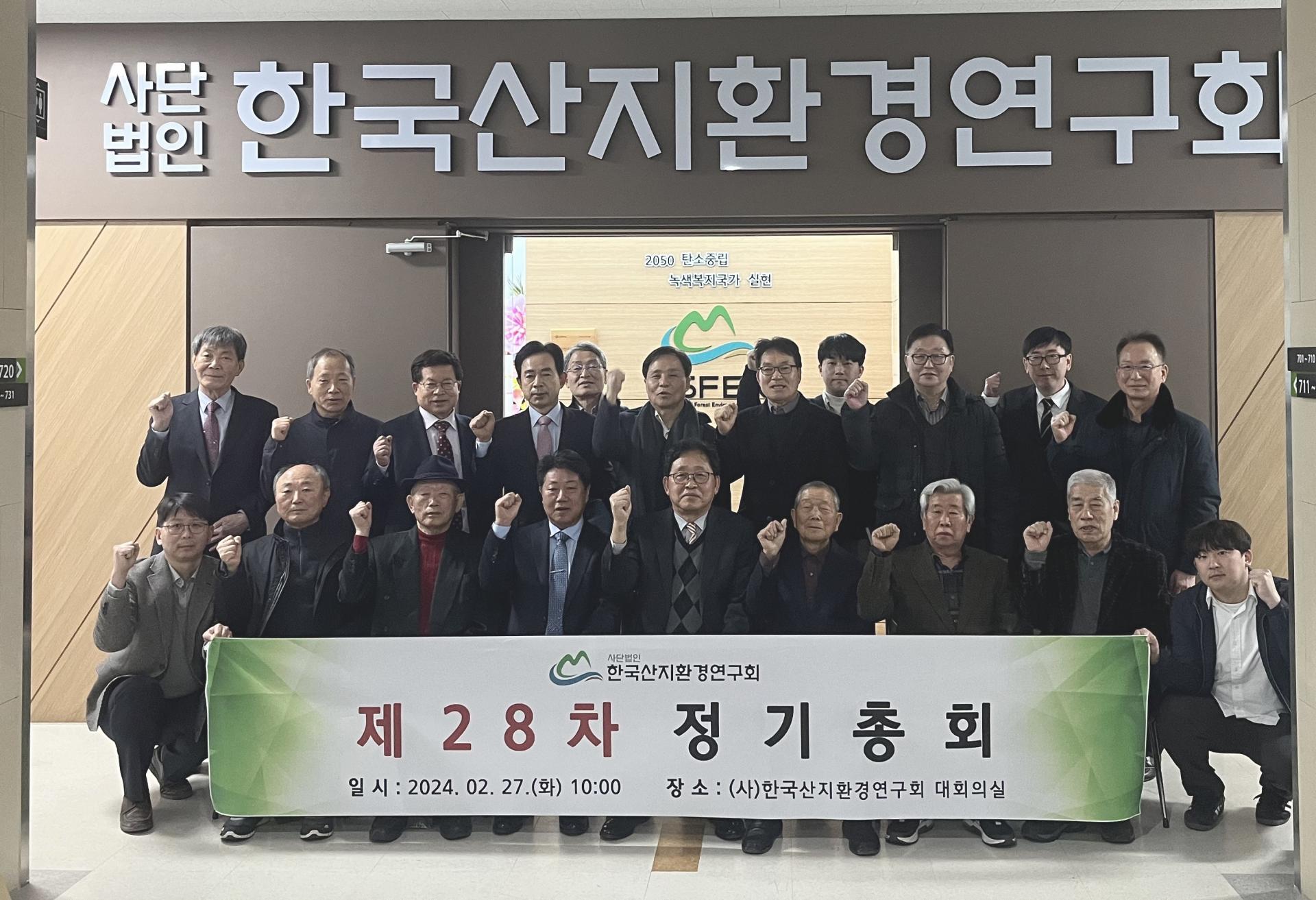 제28차 정기총회를 마친 회원들이 현수막을 들고 단체로 기념하는 모습
