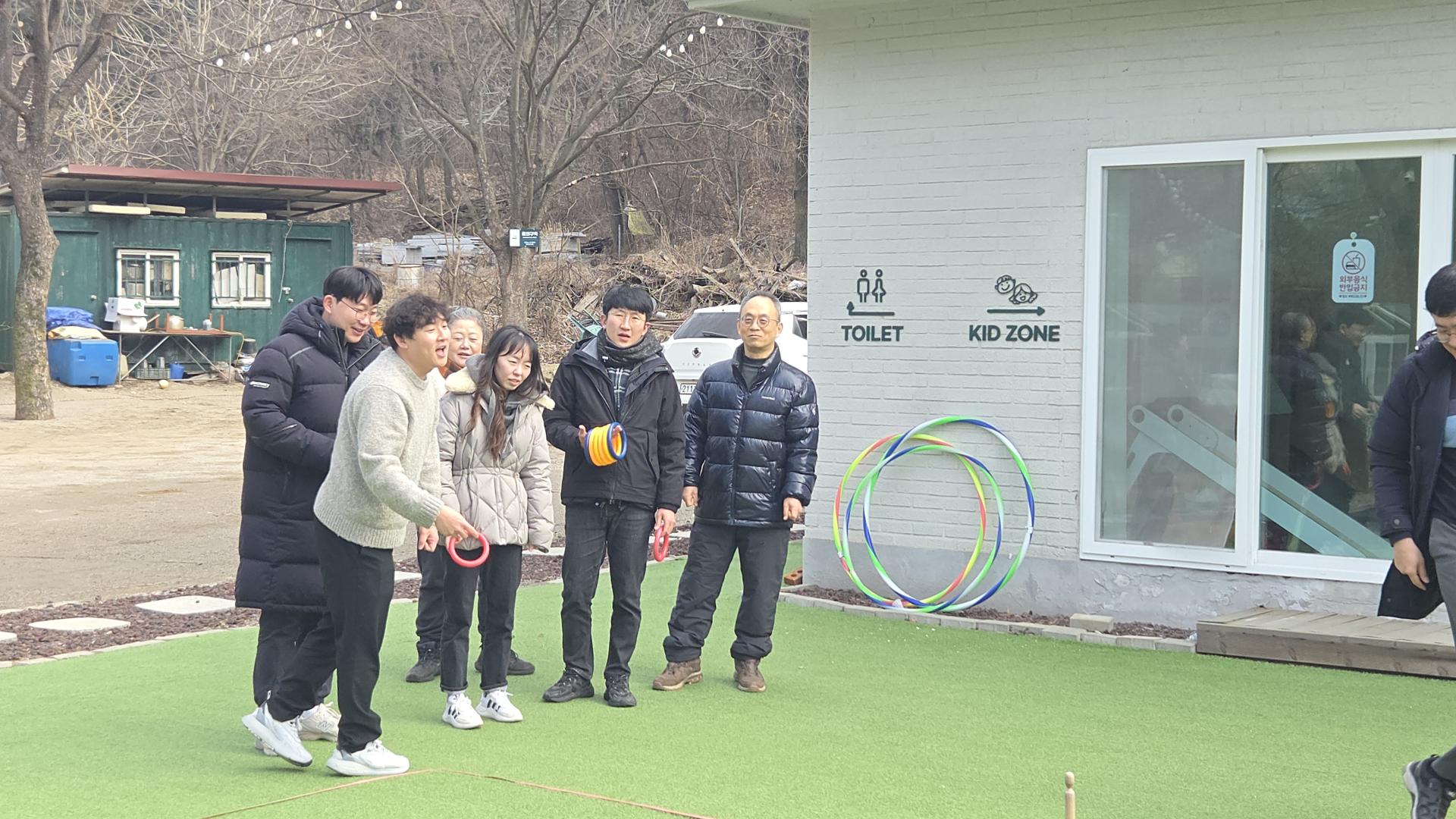 잔디마당에서 고리 던지기 게임을 하는 직원들