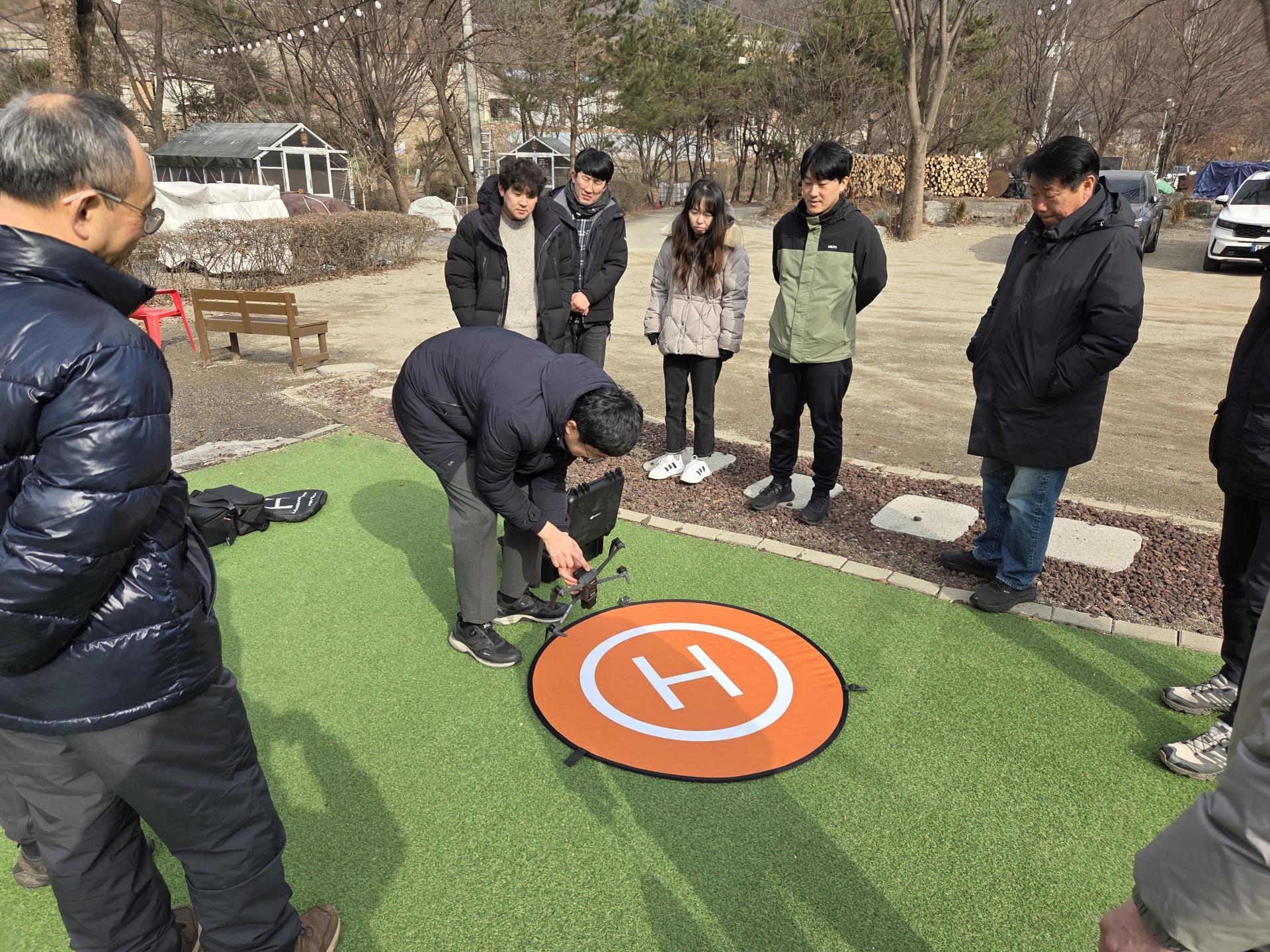 직원이 착륙패드 위의 드론을 점검하는 모습