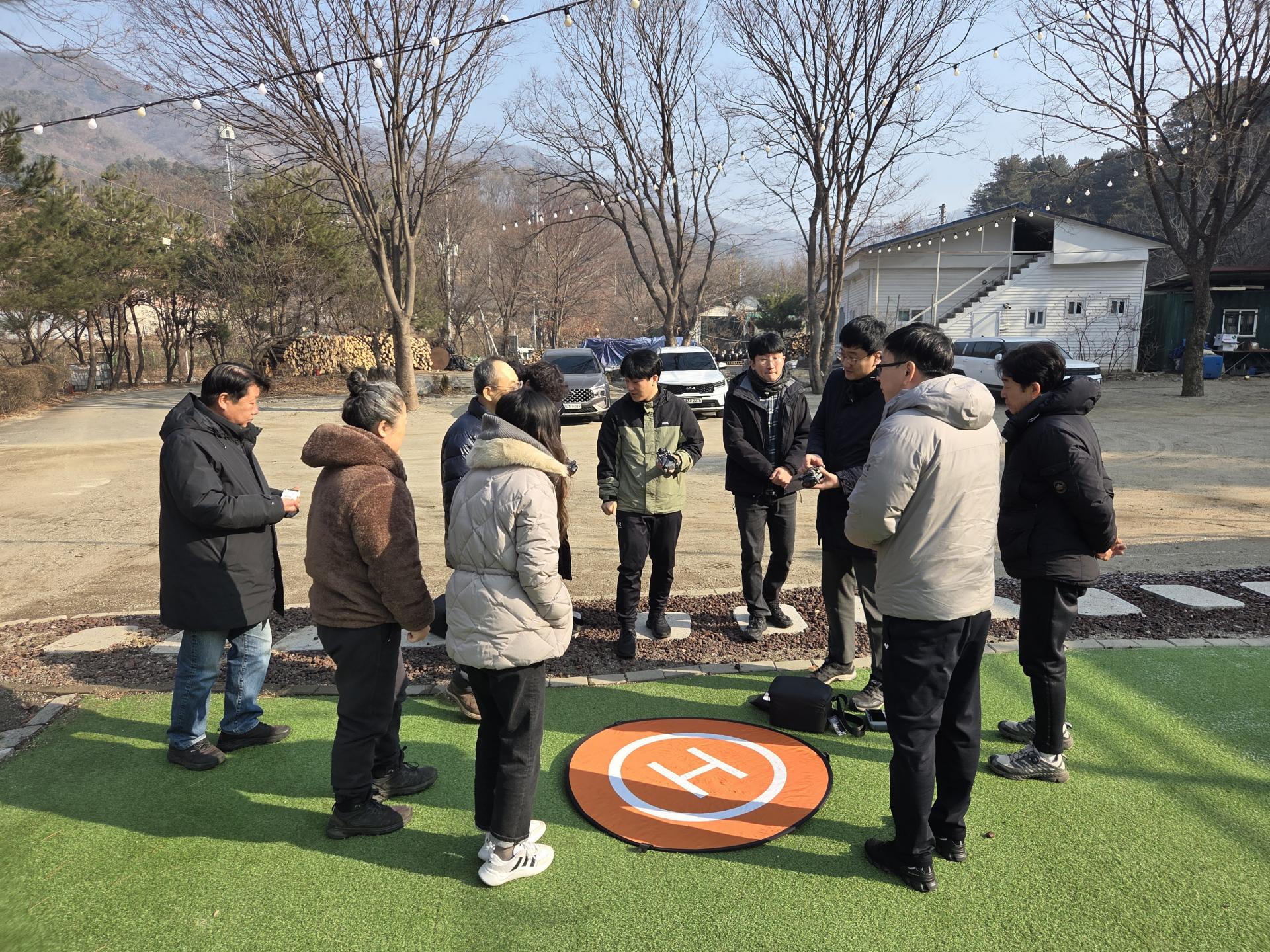 야외 잔디밭에서 드론 조종 교육을 받는 직원들