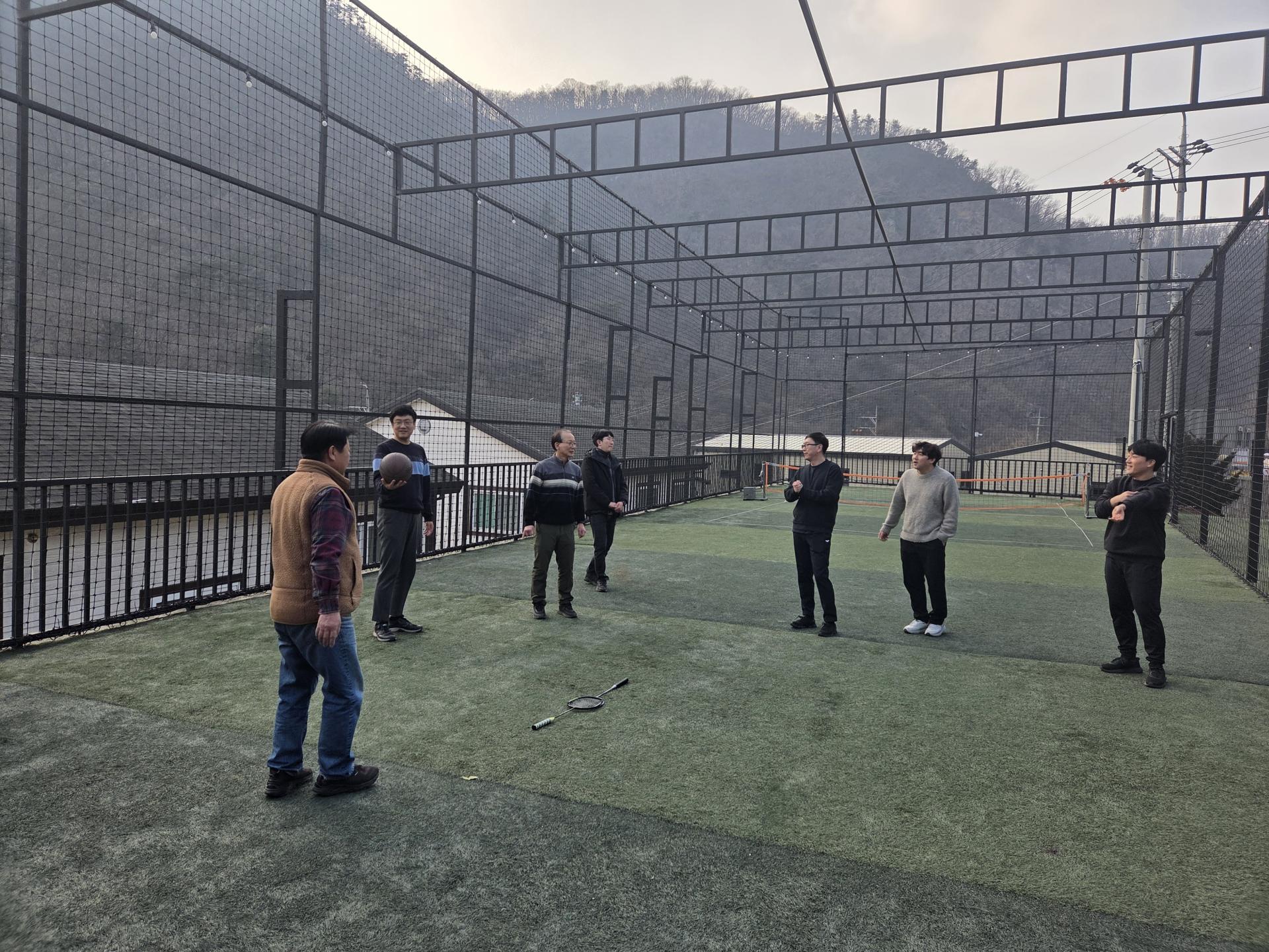 철망 코트에서 공놀이를 하는 직원들